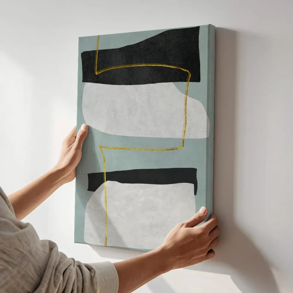 Canvas schilderij in saliegroen met gouden lijnen wordt schuin tegen een witte muur gehouden